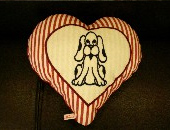 Ein Handgefertigtes Herzkissen mit ein Abdruck von ein Hund